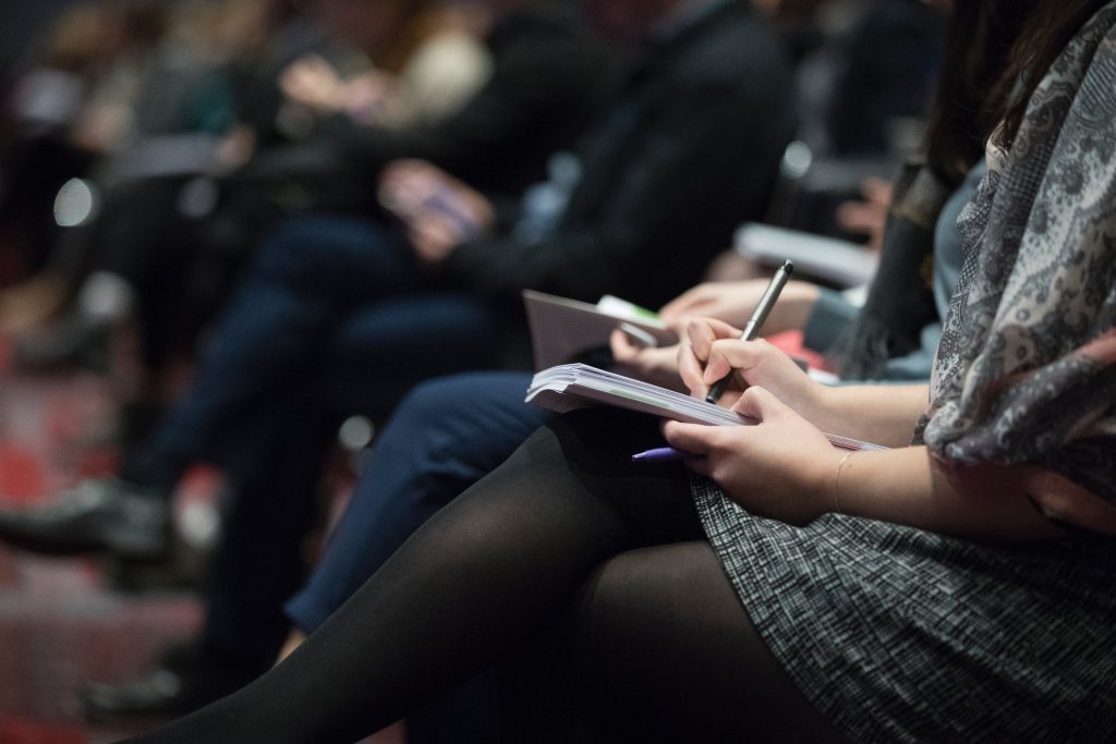 Invités lors d'un séminaire en train de prendre des notes